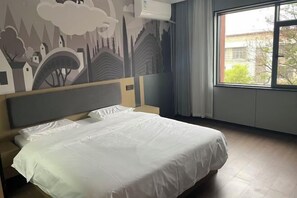 Makuuhuone, jossa on sänky, sängynpääty, ikkuna ja seinämaalaus.