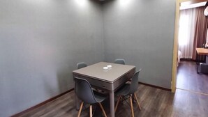 Una sala de conferències amb una taula i quatre cadires, una llum al sostre i un paviment de fusta.