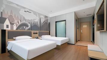 A hotel room with two beds, a TV, a mural on the wall, and a wooden floor.