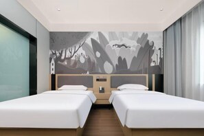 Een hotelkamer met twee bedden, een groot muurschildering en een houten vloer.