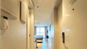 A hotel hallway with a bed, a desk, and a window. - Quality by Hosppedar (João Pessoa)