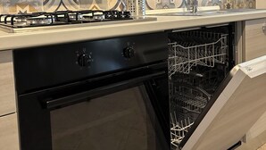 A kitchen with a built-in dishwasher, stove, and oven. - Mutina Suite 3 (Modena)