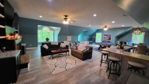 A spacious living area with a fireplace, a pool table, and a kitchen area. - 17 ft Swim Spa, hot tub, pool table, kayaks, 3 kitchens, wifi (Moneta)