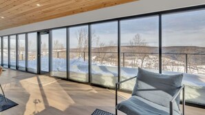 A spacious room with large windows offering a view of a snowy landscape. - Breathtaking views, modern container design (Little Valley)