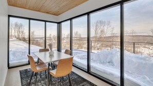 A modern interior with large windows, a dining table, and chairs. - Breathtaking views, modern container design (Little Valley)