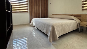 Ein Schlafzimmer mit Bett, Kleiderschrank und Fernseher.