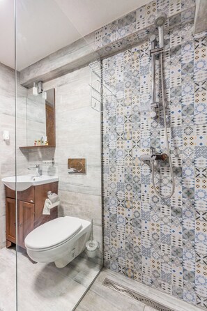 Ein modernes Badezimmer mit einer einbruchsicheren Duschkabine, einer weißen Toilette und einem мраморном Waschbecken.