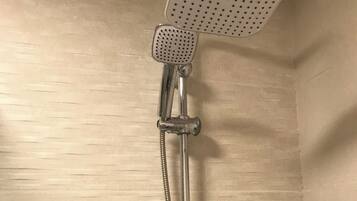 Una ducha con cabezal de ducha de mano y manguera flexible.