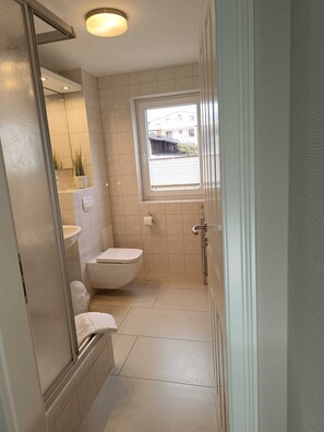 Een haardroger, handdoeken, zeep, toiletpapier
