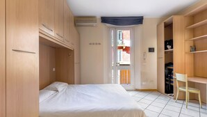Une chambre à coucher avec un lit, une armoire en bois et une chaise.