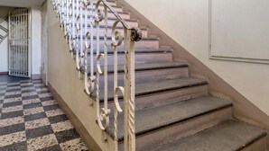Un escalier orné de rampes en métal ouvragé et doté d’un motif de sol à carreaux.
