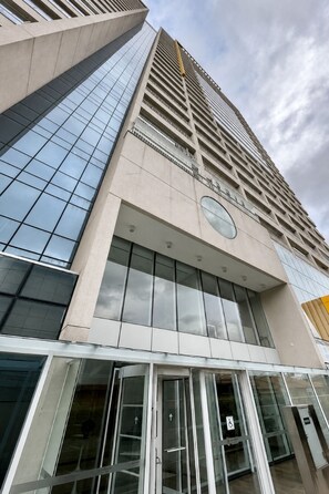 A modern building with a glass facade, a prominent entrance with glass doors, and a visible elevator.