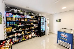 A self-service beverage station with a Nestlé cooler and a refrigerated display.