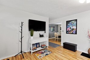 Relax in this stylish living room with a flat-screen TV, sofa, and colorful rug.