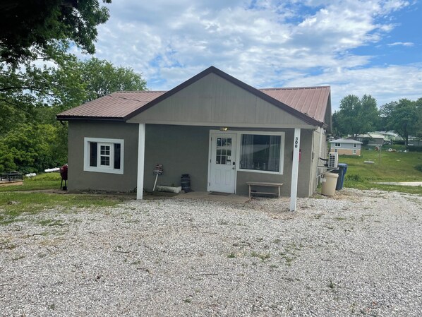 A single-story building with a sloped roof, a front door, and a small porch area. - Nana’s Bunkhouse is a small little efficiency located in Houston, MO.  (Houston)