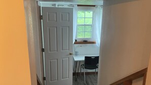 A narrow stairway leading to a room with a desk, chair, and window. - Nana’s Bunkhouse is a small little efficiency located in Houston, MO.  (Houston)