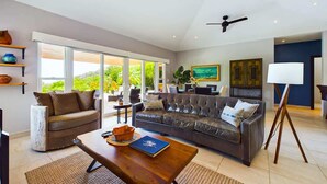 A spacious living room with a leather sofa, a coffee table, and a painting on the wall. - Casa Rebanada de Vida (Mar Vista)