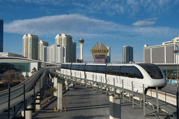 Une gare moderne avec un train à grande vitesse, une tour imposante et une enseigne Westgate.