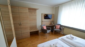 A hotel room with a bed, a desk, a TV, and a wardrobe. - Pension Nordlicht (Esens)