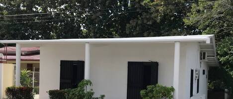 A single-story building with a flat roof, two black-framed windows, and a white exterior.