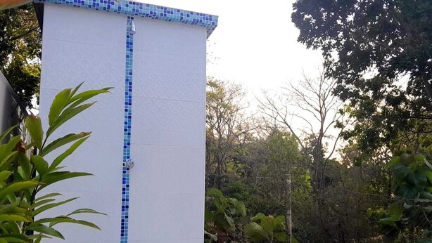 Zona de piscina con pared de azulejos y vista despejada a la piscina.