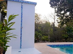 Zona de piscina con pared de azulejos y vista despejada a la piscina.