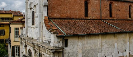 A historic building with a prominent tower and a courtyard.