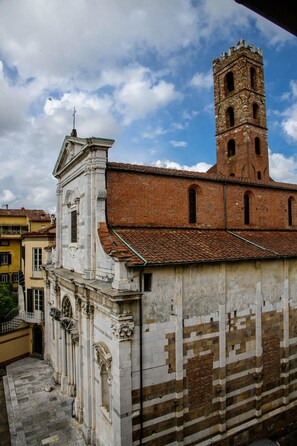 Um edifício histórico com uma torre imponente e um pátio.