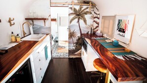 A compact kitchen with wooden countertops, a sink, and a small dining area. - Arre Lulu Baja (Valle de Guadalupe)