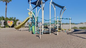 A playground with a slide and climbing structures on a sandy beach. - Myrtle Beach 'Coastal Cabana' w/ Resort Amenities! (Myrtle Beach)