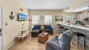 Un espacio habitable compacto con kitchenette, un sofá, una mesa de centro y un comedor.