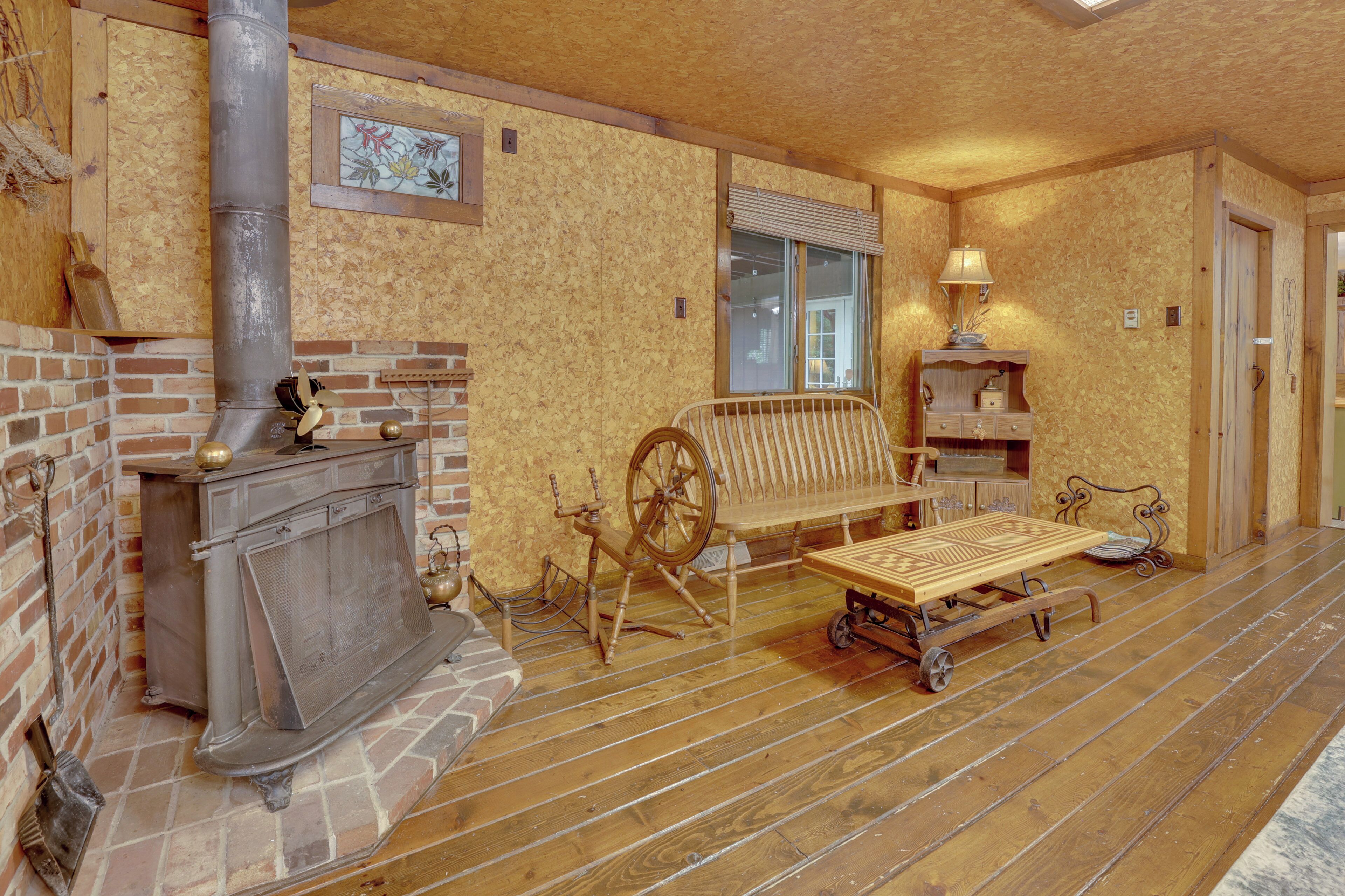 Una habitación acogedora con chimenea de ladrillo, muebles de madera y una ventana con persianas.