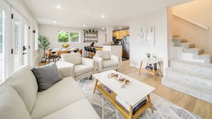Una sala de estar moderna con sofá, una mesa de centro y un comedor con sillas y una mesa.