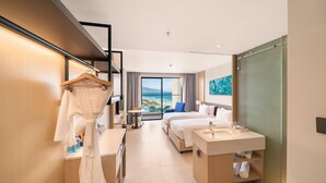 A modern hotel room with a balcony, a bed, a desk, and a bathroom. - Arena Cam Ranh Ocean View Resort (Bac Cam Ranh)