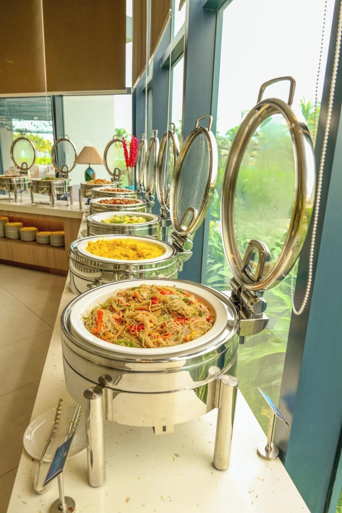 Un'area buffet con diverse postazioni, ciascuna dotata di coperchio e cucchiaio.