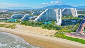 A resort with multiple high-rise buildings, a beachfront, and a large swimming pool area. - Arena Cam Ranh Ocean View Resort (Bac Cam Ranh)