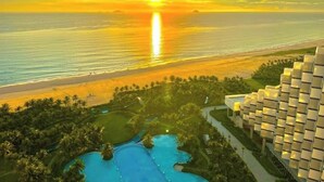 A resort with a pool area, a beach, and a sunset view. - Arena Cam Ranh Ocean View Resort (Bac Cam Ranh)