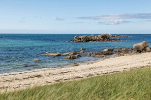 A coastal beach with clear blue water, rocky outcrops, and sandy shore. - Maison avec piscine - accès plage à pied (Plouescat)