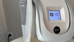 Een waterdispenser met een digitaal scherm waarop staat 'Meer water, alstublieft'.