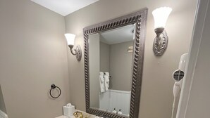 Een badkamer met twee wastafels, een grote spiegel en een haardroger.