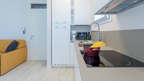 A compact kitchen with a built-in oven, a microwave, and a sink. - Appartamento Valeria by Wonderful Italy (Sirmione)
