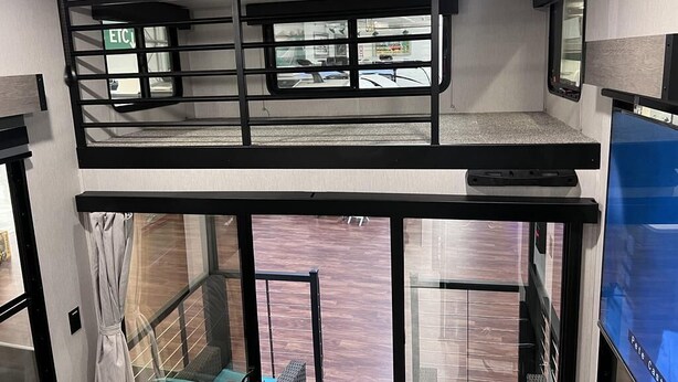 A bunk bed room with a window view, a ceiling fan, and a TV. - Ridgetop Retreat Tiny Home, Dakota MN (Dakota)
