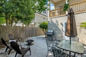 An outdoor patio with a grill, chairs, and a table. - Chic’s Beach 3BR Home + Walk to Beach + 30+ Nights (Virginia Beach)