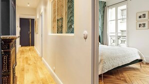 A bedroom with a bed, a window, and a door.