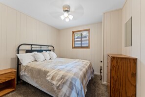 A bedroom with a bed, a wooden nightstand, a dresser, a ceiling fan, and a window with blinds. - 2BR Duplex Cabin w/Community Pool + Boat dock (Branson West)