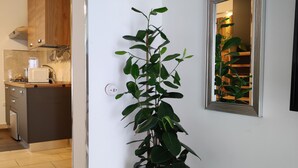 Una cuina moderna amb armaris de fusta, un microones i una planta en test.