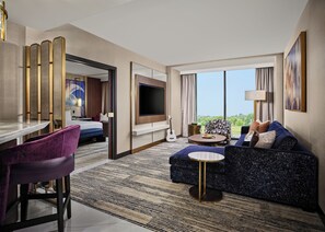 A modern hotel room with a bed, seating area, TV, and a view of the outdoors. - Hard Rock Hotel & Casino Ottawa (Ottawa)