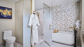 A modern bathroom with a toilet, a glass-enclosed shower, and a bathtub.
