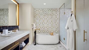 A modern bathroom with a large mirror, a bathtub, and a walk-in shower.