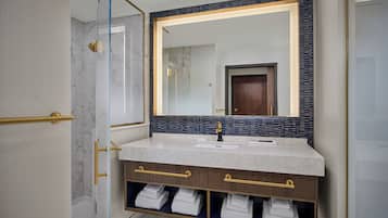 Une salle de bain moderne avec un meuble-lavabo en marbre, un grand miroir et un porte-serviettes intégré.